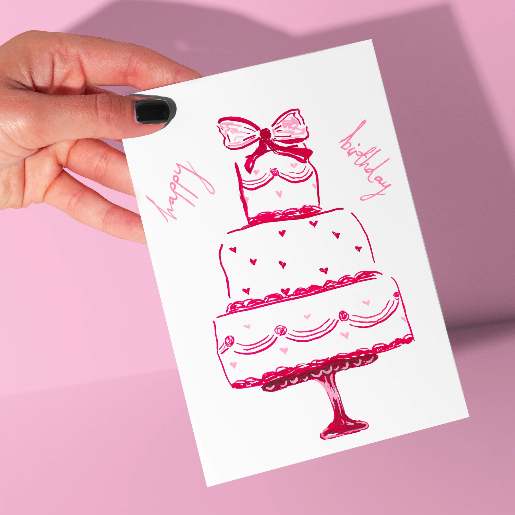 Happy Birthday Cake Card by Tecari Designs being held up in front of a pink background