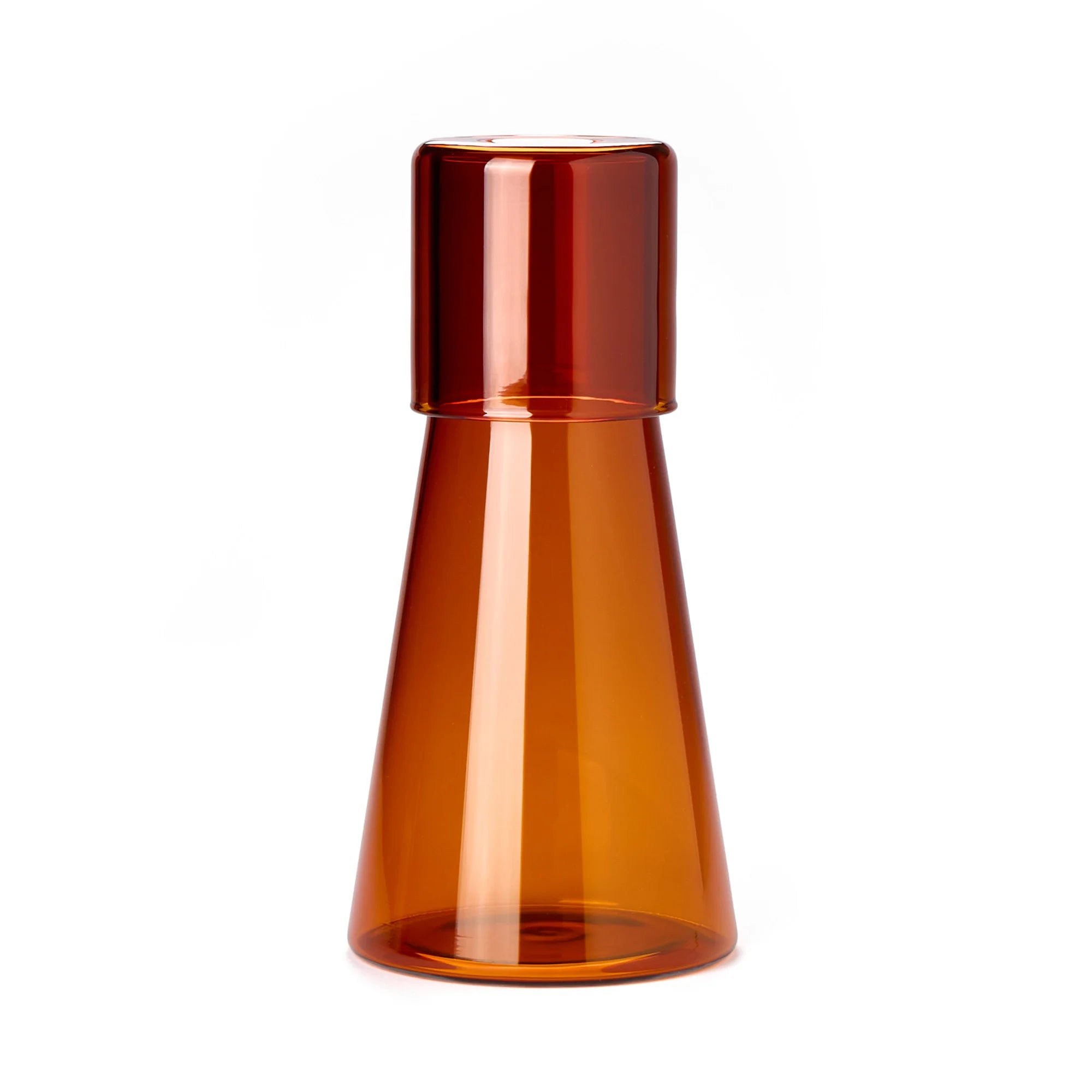 Amber transparent carafe with glass as lid on a white background