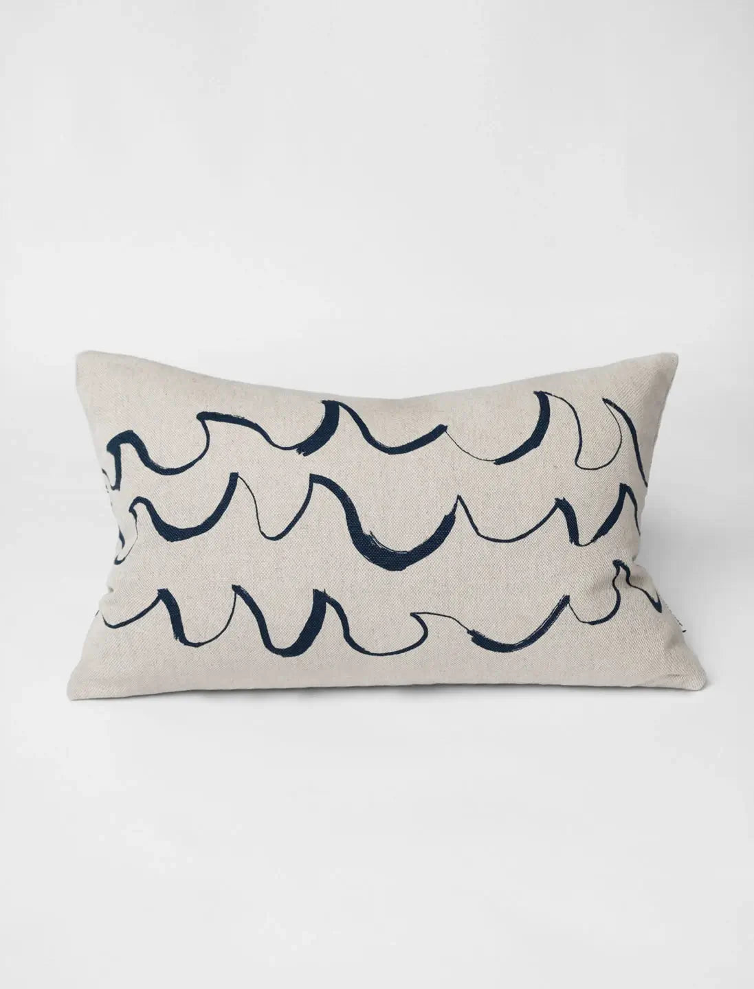 A long cushion in natural linen with a minimal blue wave shaped brush stroke motif from Fine Little Day