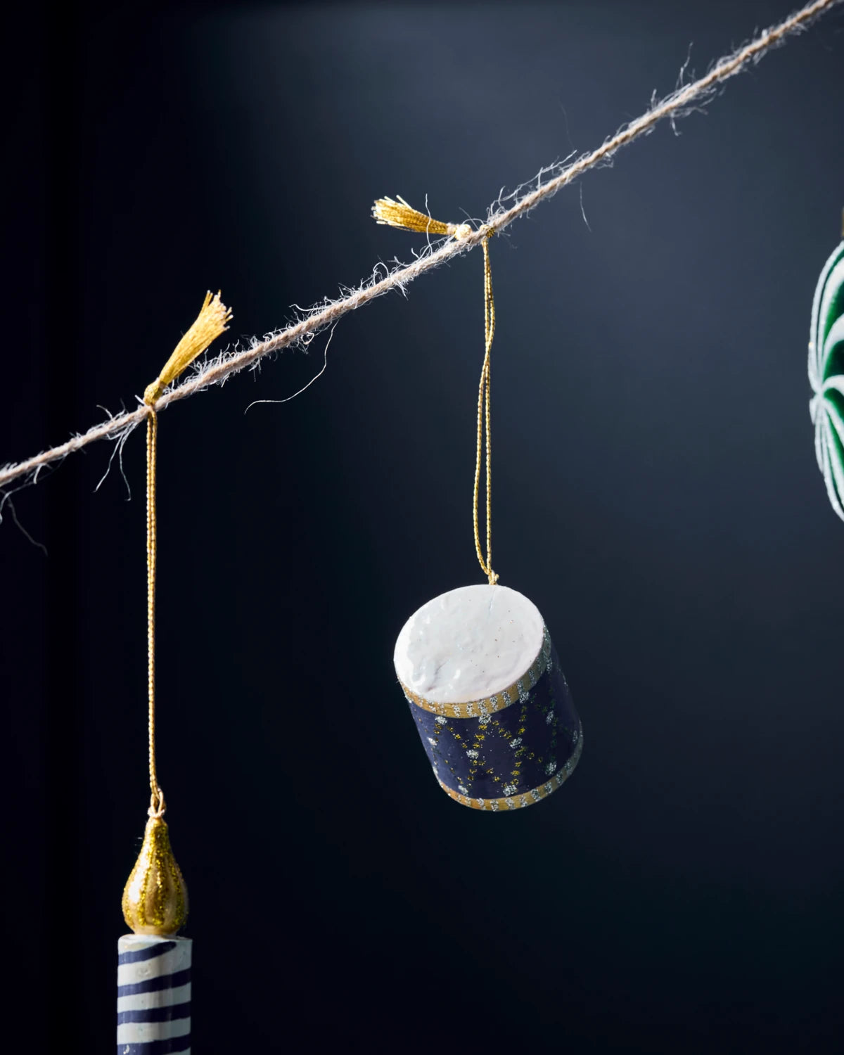 House Doctor blue Wooden Drum Hanging Ornament hanging from twine with other ornaments against a dark background