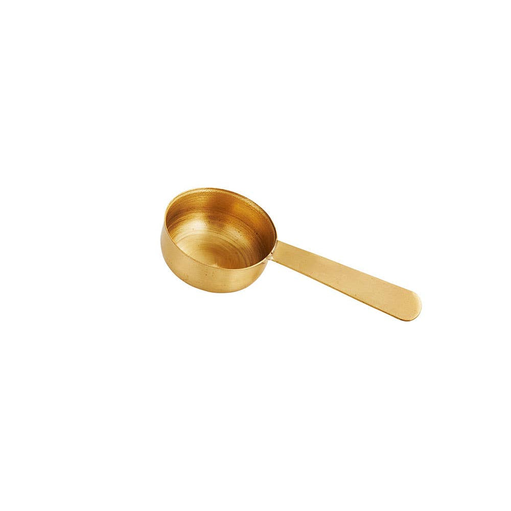 brass coffee measuring spoon on a white background
