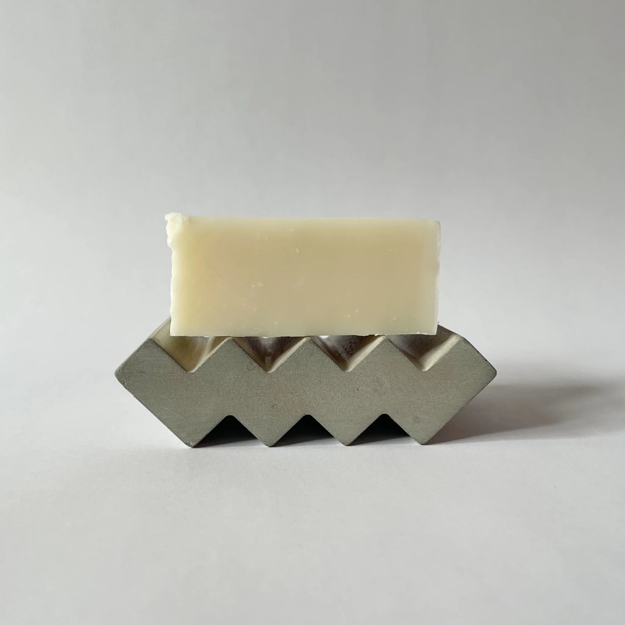 Grey soap dish made of cast concrete. Zig zag in shape, it's solid and waterproof 